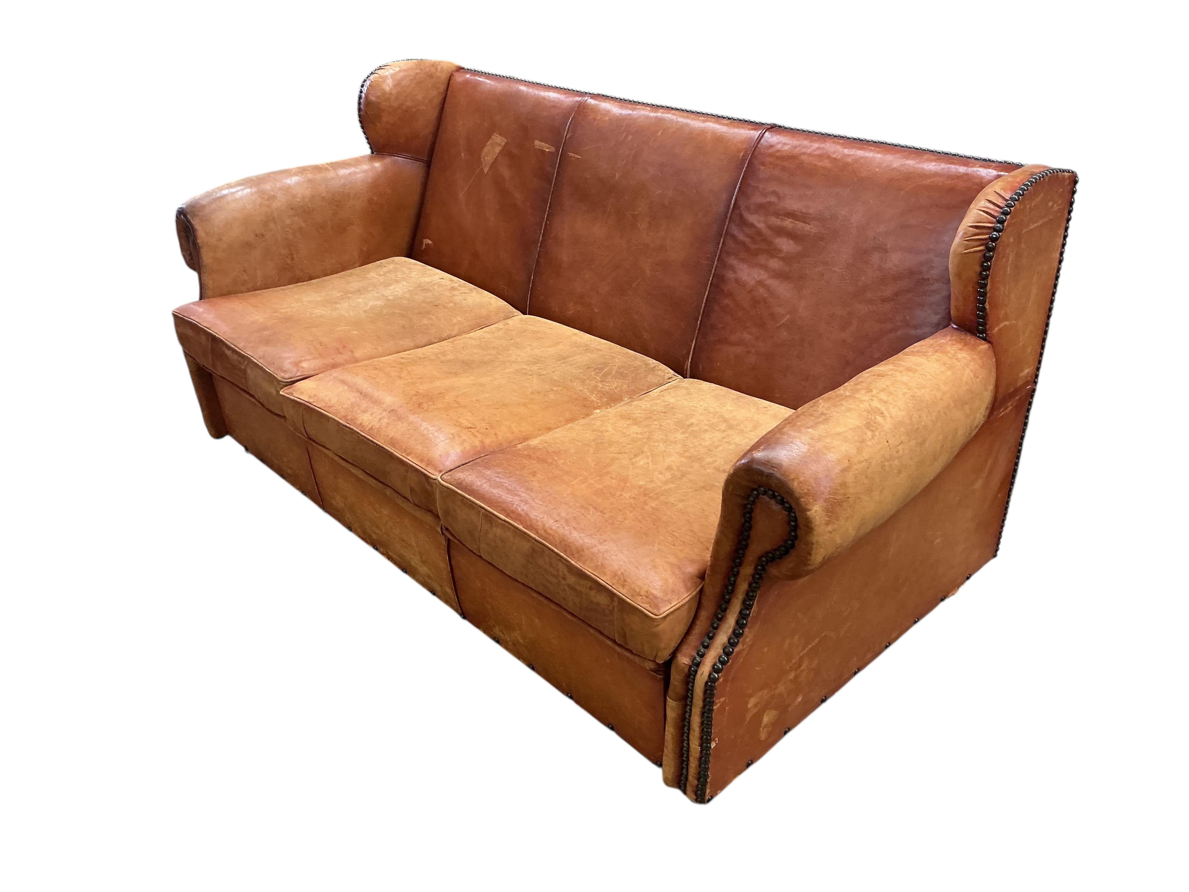 A brass studded tan leather three seater sofa bed, width 180cm, depth 90cm, height 86cm